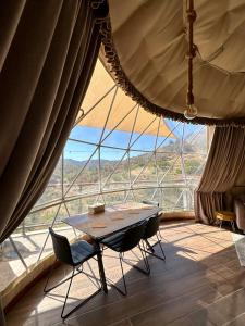 a table and chairs in a room with a large window at Agros Glamping Boutique in Agros