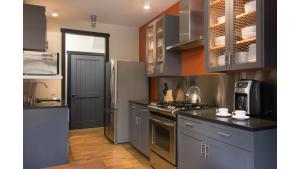 a kitchen with gray cabinets and a refrigerator at Bavarian Chalet 1 in Taos Ski Valley
