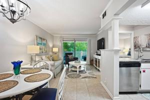 a kitchen and living room with a table and chairs at Shipwatch #114 in East End