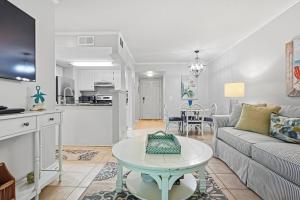 a living room with a couch and a table at Shipwatch #114 in East End +22 photos