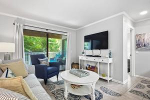 a living room with a couch and a table at Shipwatch #114 in East End