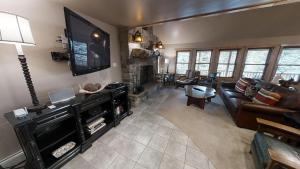a living room with a couch and a flat screen tv at Antlers Riverside Lodge in Red River