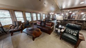 a living room with couches chairs and a table at Antlers Riverside Lodge in Red River