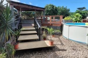 a backyard with a swimming pool and a deck with a stairway at Spacious Family House with Pool in Afareaitu