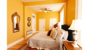 a bedroom with yellow walls and a bed and a mirror at William F. Cody in Cimarron