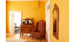 a room with a chair and a mirror and a dresser at William F. Cody in Cimarron