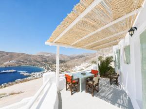 a white house with a table and chairs on a balcony at Uranos studios Amorgos in Amorgos