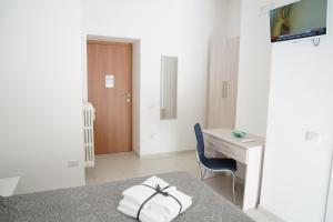 Habitación con escritorio y cama con toallas. en La Casa dei Sogni, en Matera