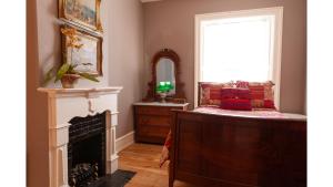 a room with a mirror and a bed and a fireplace at Bat Masterson in Cimarron