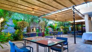 a patio with tables and chairs and a wall of plants at Hôtel Résidence le Berger in Nouakchott