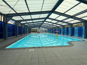 a large swimming pool with a glass ceiling at Caseo Gramsbergen in Gramsbergen