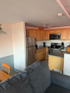 a kitchen with a couch and a refrigerator and a table at Trade Winds on the Bay in Rockland