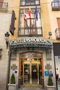 a hotel las moroccas with two flags in front of it at Hotel Las Moradas in Ávila
