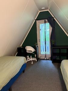 a attic room with two beds and a window at Caseo Gramsbergen in Gramsbergen +22 photos