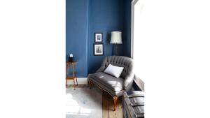 a living room with a chair and blue walls at Annie Oakley in Cimarron +2 photos