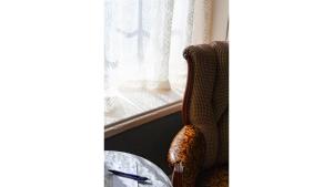 a chair next to a table and a window at Annie Oakley in Cimarron