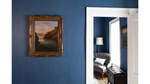 a painting hanging on a blue wall in a living room at Annie Oakley in Cimarron