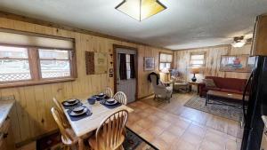 a room with a table and chairs and a living room at Knotty & Nice in Red River