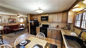 a kitchen with wooden cabinets and a table with a dining room at Knotty & Nice in Red River
