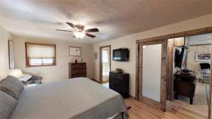 a bedroom with a bed and a ceiling fan at Knotty & Nice in Red River +8 photos