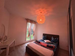 a bedroom with a bed and a chandelier at Cocon avec petit jardin centre Bondy in Bondy