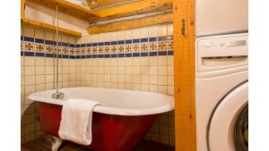 a bath tub in a bathroom next to a washing machine at Denton Cabin in Taos Ski Valley
