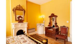 a bedroom with yellow walls and a fireplace and a mirror at Pancho Griego in Cimarron