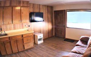 a kitchen with wooden cabinets and a flat screen tv at A Frame of Mind in Red River