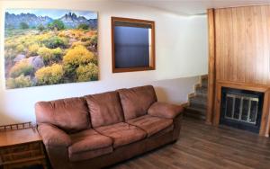 a living room with a brown couch and a fireplace at A Frame of Mind in Red River