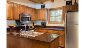 a kitchen with wooden cabinets and a stainless steel refrigerator at Twining 7 in Taos Ski Valley