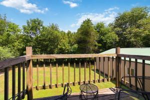 a deck with chairs and a fence with a field at Beaver Lake Hideaway in Lowell