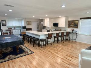 a large kitchen with a counter and chairs in it at The Loft in McKinney +16 photos