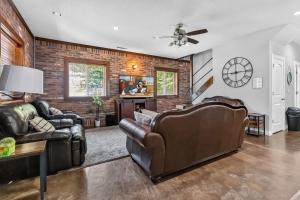 a living room with leather furniture and a brick wall at Beaver Lake Hideaway in Lowell