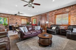 a living room with leather furniture and a brick wall at Beaver Lake Hideaway in Lowell +23 photos