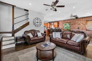 a living room with two leather couches and a table at Beaver Lake Hideaway in Lowell