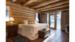 a bedroom with a bed in a log cabin at Denton Cabin in Taos Ski Valley