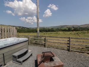 a bath tub sitting next to a wooden fence at Tin Shed in Rhayader