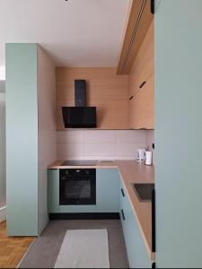 a kitchen with white cabinets and a black oven at The Olive Branch in Sarajevo