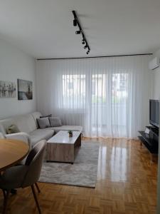 a white living room with a couch and a table at The Olive Branch in Sarajevo