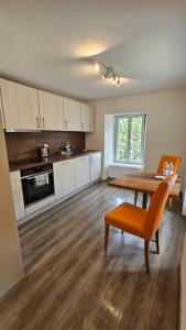 a kitchen with a wooden table and a dining room at Haus Alpenhof in Wassen