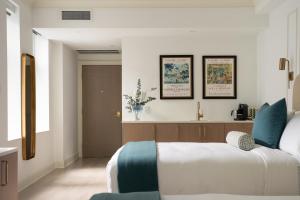 a bedroom with a bed and two pictures on the wall at Manoir Émery in Montreal