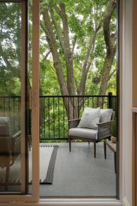a porch with a couch and a chair on a balcony at Manoir Émery in Montreal