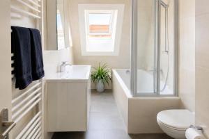 a bathroom with a tub and a toilet and a sink at SCHEE Panorama Apartment - ideal für Gruppen und Familien in Nördlingen