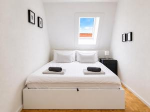 a white bedroom with a large white bed with two pillows at SCHEE Panorama Apartment - ideal für Gruppen und Familien in Nördlingen