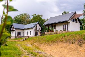 two white houses with black roofs on a hill at K-Home in Stănija