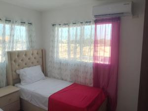 a small bedroom with a bed and a window at Rinconcito Caribeno Apartment in San Pedro de Macorís