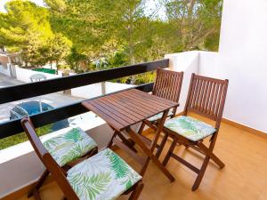 two chairs and a wooden table on a balcony at Formenterasuite 16 in Es Pujols