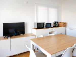 a dining room with a table and a tv at Formenterasuite 16 in Es Pujols