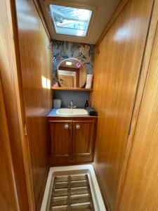 a small bathroom with a sink and a mirror at Bateau Erebus - Bohême chic in Narbonne +8 photos