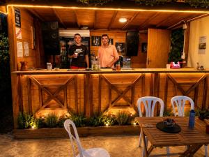 two men standing at a bar in a restaurant at Camping Nysa Paziols in Paziols